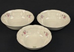 Chodziez, Polônia. Três saladeiras em porcelana esmaltada no tom marfim, decoradas com motivos florais e filetes dourados. Manufatura no verso. Medindo: 7 x 24 cm e 7 x 23 cm.