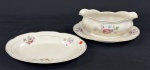Chodziez, Polônia. Travessas e molheira em porcelana esmaltada no tom marfim, decorada com motivos florais e filetes dourados. Manufatura no verso. Medindo: 9 x 23 x 17 cm e 24 x 17 cm. Travessa com lasca.