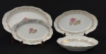 Porcelana Schmidt. Saladeira e 3 travessas em porcelana esmaltada, decorados com motivos florais e ricos detalhes em ouro. Bordas onduladas, ramos nas extremidades em relevo e filetes em ouro Manufatura no verso. Medindo: 6 x 29 x 20 cm e 29 x 18 cm (menor) 38 x 24 cm. Maior com lasca na borda.