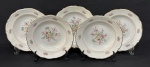 C. Tielsch & Co., Polônia, década de 1940. Cinco pratos fundos em porcelana esmaltada na cor branca, decorados com delicados ramalhetes florais em policromia, frisos dourados e bordas onduladas. Manufatura no verso. Medindo: 4,5 x. 23,5 cm.