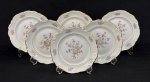 C. Tielsch & Co., Polônia, década de 1940. Seis pratos para sobremesa em porcelana esmaltada na cor branca, decorados com delicados ramalhetes florais em policromia, frisos dourados e bordas onduladas. Manufatura no verso. Medindo:19,5 cm. Um com bicado.