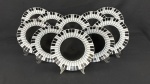 Fitz and Floyd, coleção Piano, Elisabeth Wey, 19871988. Dez pratos rasos em porcelana esmaltada, com design temático representando teclas de piano em preto e branco e centro em tom preto brilhante. Assinados no verso. Medindo:24 cm