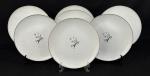 Noritake, Japan. Sete pratos rasos em porcelana japonesa esmaltada, decorados com delicados motivos florais e filetes em ouro. Manufatura no verso. Medindo: 27 cm.