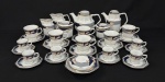Schmidt, Brasil. Serviço para chá e café em porcelana esmaltada, em formato oitavado, decoração estilizada com policroma e frisos dourados. Composto por um bule para chá, um bule para café, uma leiteira, uma cremeira, dois açucareiros, uma manteigueira, 12 xícaras com seus pires para chá e 11 xícaras com seus pires para café. Manufatura no verso. Medindo: 14,5 cm de altura (bule para chá); 16 cm de altura (bule para café); 12 cm de altura (leiteira); 10 cm de altura (cremeira); 10,5 x 9 cm (açucareiro); 14,5 cm de diâmetro (manteigueira). Cremeira com trinca.