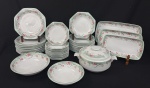 Schmidt, Brasil. Serviço para jantar em porcelana esmaltada, em formato oitavado, decorado com motivos florais em policromia. Composto por uma sopeira, duas saladeiras, três travessas, 12 pratos rasos, 12 pratos fundos e 12 pratos para sobremesa. Manufatura no verso. Medindo: 15 x 30 x 23 cm (sopeira); 6 x 26 cm e 6 x 22 cm (saladeiras); 35 x 22 cm, 33 x 19 cm e 29 x 16 cm (travessas); 25 cm de diâmetro (pratos rasos); 21,5 cm de diâmetro (pratos fundos); 19 cm de diâmetro (pratos para sobremesa).