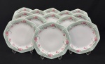 Schmidt, Brasil.  Treze pratos rasos em porcelana esmaltada, em formato oitavado, decorado com motivos florais em policromia. Manufatura no verso. Medindo: 2,5 x 24 cm.