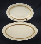 Vista Alegre, Portugal. Duas travessas em porcelana portuguesa esmaltada na cor creme, com frisos em ouro. Manufatura no verso. Medindo:3 x 29 x 20 cm e 4 x 23 x 33 cm.