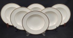 Royal Doulton, England. Seis pratos fundos em porcelana inglesa esmaltada na cor branca, com frisos em ouro. Manufatura no verso. Medindo: 4,5 x 26 cm. 