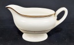 Royal Doulton, England. Uma molheira em porcelana inglesa esmaltada na cor branca, com frisos em ouro. Manufatura no verso. Medindo: 8 x 16 cm. Apresenta manchas na alça e fundo. 