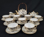 Porcelana japonesa, dita `casca de ovo`. Serviço para chá em porcelana esmaltada, com delicada pintura manual em policromia e filetes em ouro. Composto por um bule de chá com alça em bambu, um açucareiro, uma leiteira e nove xícaras de chá com seus respec