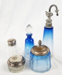 Conjunto para toucador. Conjunto composta por cinco peças em cristal translúcido e azul, com tampas e acabamentos em metal prateado, incluindo saleiro com tampa em prata. Medindo: 17 cm de altura (maior peça). Observação: Quatro peças apresentam bicados e trincas.