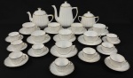 Mauá. Serviço para chá e café em porcelana, esmeralda na cor branca, bordas serrilhadas e filtradas à ouro, composto de 2 bules, açucareiro, 8 xícaras para chá e 9 para café. Detalhes em dourado com desgastes e duas xícaras para chá e 3 de café com fios de cabelo. Alt. bule maior 21cm.