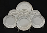 Mauá. Conjunto de prato para bolo e 10 pratos para sobremesa em porcelana esmaltada na cor branca, bordas serrilhadas e filtradas à ouro. Medindo: Fio de cabelo no prato de bolo. 
