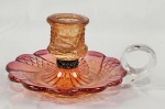 Palmatória em cristal Baccarat, na cor cereja, apresentando discretos bicadinhos e restauro no corpo abaixo do porta-velas. Med. 7 x 15 x 12,5 cm. 