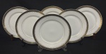 Mauá. Seis pratos rasos em porcelana esmaltada, decoração com friso preto e detalhes em dourado. Manufatura no verso. Med. 24 cm diâm. 