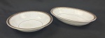 Mauá. Duas saladeiras em porcelana esmaltada, decoração com friso preto e detalhes em dourado. Manufatura no verso. Med. 5 x 20 x 28 cm e 5 x 23 cm.