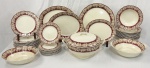 Cream Petal. Inglaterra. Imponente aparelho de jantar em faiança inglesa esmaltada, decoração em rica policromia com faixa vinho ornamentada por folhas de parreira, cachos de uvas e arabescos em dourado, composição inspirada nos tradicionais serviços europeus de mesa do início do século XX. Peças com bordas recortadas e delicadamente moldadas, conferindo elegância e presença ao conjunto. Composto de: 12 pratos rasos, 12 pratos fundos, 10 pratos para sobremesa, 1 sopeira, 1 travessa redonda, 3 travessas ovais sendo uma funda e 2 saladeiras. Manufatura no verso. Total de 40 peças. Sopeira apresenta mínimo bicado. Uma das travessas ovais apresenta lascado na borda. Conjunto com manchas e marcas do tempo, compatíveis com o tempo e uso das peças