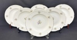 Seis pratos fundos em porcelana da República Tcheca, esmaltados na cor branca, decoração floral policroma e filetes em ouro, bordas com ramos em relevo. Med. 4 x 25 cm.
