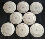 Oito pratos de sobremesa em porcelana da República Tcheca, esmaltados na cor branca, decoração floral policroma e filetes em ouro, bordas com ramos em relevo. Med. 20 cm diâm. 