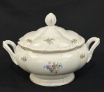 Sopeira em porcelana da República Tcheca, esmaltada na cor branca, decoração floral policroma e filetes em ouro, bordas com ramos em relevo. Med. 23 x 30 x 23 cm.
