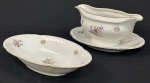Molheira e porta-covilhetes em porcelana da República Tcheca, esmaltados na cor branca, decoração floral policroma e filetes em ouro, bordas com ramos em relevo. Med. 10 x 22 x 16 cm e 4 x 24 x 13 cm.