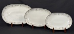 Porcelana Real, Brasil, década de 1960/70. Três travessas rasas ovais em porcelana esmaltada, decoração com rica guirlanda floral nas tonalidades cinza e rosa. Manufatura no verso. Medindo: 38 x 25 cm à 19 x 28 cm. 