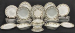 TK Thun, Tchecoslováquia, década de 1950/60. Elegante aparelho de jantar em porcelana esmaltada, decorado com friso contínuo de folhagens nas tonalidades verde e amarelo, enriquecido por delicadas flores policromas no centro das peças. Bordas suavemente moldadas com acabamento clássico, característica da manufatura. Composto de: 21 pratos rasos, sendo 3 com trincados; 12 pratos fundos; 12 pratos para sobremesa, sendo 5 com lasca no fundo da borda; 5 travessas ovais, 2 travessas quadradas, 1 travessa redonda, 1 prato redondo, 1 sopeira com tampa, 1 sopeira sem tampa, apresentando fio de cabelo e 1 molheira. Manufatura no verso. Total de 57 peças.