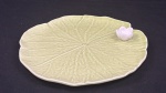 Bordallo Pinheiro, Portugal. Porta-cartão em porcelana portuguesa esmaltada e policromada, modelada na forma de folha naturalista com flor em alto-relevo aplicada, composição característica da renomada manufatura portuguesa. Marca da manufatura na base. Med. 23 cm diâm