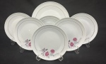 Schmidt, Santa Catarina. Conjunto para sobremesa em porcelana branca esmaltada, decoração floral policroma e friso interno em dourado, composto de: prato de bolo e 6 pratos para sobremesa. Manufatura no verso. Medindo; 26 cm 19,5 cm diâm. Total de 7 peças