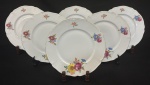 Hutschenreuther, Bavária, década de 1930. Seis pratos rasos em porcelana esmaltada, decoração floral policroma e frisos em ouro sobre fundo branco. Manufatura no verso. Medindo: 25 cm. 