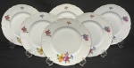 Hutschenreuther, Bavária, década de 1930. Seis pratos para sobremesa em porcelana esmaltada, decoração floral policroma e frisos em ouro sobre fundo branco. Manufatura no verso. Medindo; 19 cm. 