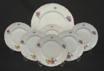 Hutschenreuther, Bavária, década de 1930. Conjunto para sobremesa composto de prato de bolo e seis pratos para sobremesa em porcelana esmaltada, decoração floral policroma e frisos em ouro sobre fundo branco. Manufatura no verso. Medindo; 19 cm e 30 cm.  