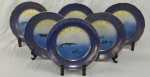 Porcelana Real. Seis pratos rasos em porcelana nacional esmaltada, decoração com peixes em policromia sobre fundo branco e azul, ricamente realçada a ouro. Bordas ornamentadas em azul cobalto com delicados motivos em ouro. Manufatura no verso. Medindo; 24 cm.