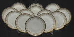 Porcelana Real, Brasil. Treze  pratos para sobremesa em porcelana branca vitrificada, decoração com faixa contínua em ouro e delicado motivo floral policromo, composto por guirlandas, flores e arabescos estilizados. Manufatura no verso. Medindo: 19 cm. 