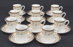 Porcelana Real, Brasil. Doze xícaras para café com 11 respectivos pires em porcelana branca vitrificada, decoração com faixa contínua em ouro e delicado motivo floral policromo, composto por guirlandas, flores e arabescos estilizados. Manufatura no verso.