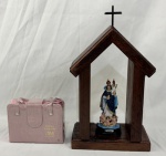 Duas peças. A) Oratório ou capela de madeira nobre (canela) contendo uma imagem Nossa Senhora da Cabeça. É invocada principalmente para cura de dores de cabeça, doenças mentais, sabedoria e discernimento. B) Bíblia Sagrada Ave Maria – Edição especial, enc