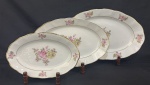 Rio Branco. Três travessas em porcelana esmaltada, decoração com buquê de flores policromas e frisos em ouro sobre fundo branco. Manufatura no verso. Medindo: 29 x 18,5 cm à 40 x 26 cm. Desgastes na borda.