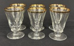 Seis cálices para licor em cristal europeu translúcido, com faixa em ouro. Medindo: 6,5 x 4,5 cm.