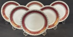 Steatita. Seis pratos para sobremesa em porcelana nacional esmaltada, decoração com larga faixa na tonalidade vinho, enriquecida por minuciosos ornamentos geométricos e arabescos, ricamente realçados a ouro, sobre fundo branco. Manufatura no verso. Medindo; 19 cm.