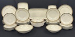 Schmidt / Casa Meyer. Refinado serviço de jantar em porcelana esmaltada na tonalidade marfim, decoração clássica composta por delicado bouquet floral policromo de forma discreta ao centro das peças, acompanhado por friso contínuo em ouro e faixa interna texturizada em tonalidade bronze/ouro nas bordas. Composto de: 12 pratos rasos, 12 pratos fundos, 12 pratos para sobremesa, 3 travessas retangulares, 1 sopeira com tampa e 2 saladeiras. Manufatura no verso. Total de 42 peças