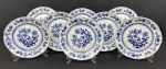 Steatita, padrão `Cebolinha`. Oito pratos rasos em porcelana esmaltada na cor branca, com rica decoração em azul. Manufatura no verso. Medindo: 24 cm. Um com fio de cabelo. 