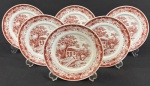 Schmidt. Seis pratos para sobremesa em porcelana esmaltada sobre fundo branco, decoração monocromática no tom grená representando cenas bucólicas de paisagem, com arquitetura rural, árvores e elementos campestres, circundadas por rica composição ornamental nas bordas. Manufatura no verso. Med. aprox. 19 cm diâm