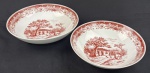 Schmidt. Duas Saladeiras em porcelana esmaltada sobre fundo branco, decoração monocromática no tom grená representando cenas bucólicas de paisagem, com arquitetura rural, árvores e elementos campestres, circundadas por rica composição ornamental nas bordas. Manufatura no verso. Medindo: 6 x 22 cm e 6,5 x 25 cm