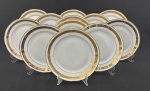 Barão do Rio Branco. Doze pratos rasos em porcelana esmaltada sobre fundo branco, decoração com faixas em ouro ornamentadas por flores e folhagens. Manufatura no verso. Pequenos desgastes no ouro compatíveis com o tempo. Med. 24 cm diâm.