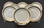 Barão do Rio Branco. Oito pratos para sobremesa em porcelana esmaltada sobre fundo branco, decoração com faixas em ouro ornamentadas por flores e folhagens. Manufatura no verso. Dois com manchas causadas pelo tempo e pequenos desgastes no ouro. Med. 19,5 