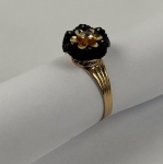 Anel `Joia de Crioula`ouro 18K. Anel feminino, aro trabalhado em ouro rosê 18K (750) contrastado, com elemento central em coco esculpido em formato de flor, aplicado com detalhes em ouro e pedra translúcida ao centro. Peça de boa execução ourives, de apel