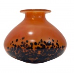 Imponente vaso em vidro artístico de Murano, em elegante tonalidade âmbar alaranjada com inclusões orgânicas em preto na base. Corpo bojudo com borda suavemente aberta, executado em vidro soprado de fino acabamento. Assinado na base. Medidas: 12 x 14 cm.