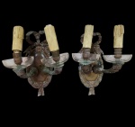 Par de apliques de parede em bronze, com braços ornamentados em forma de figuras masculinas e detalhes clássicos em relevo, acompanhados de mangas em vidro. Medidas: 28,5 x 14 x 18 cm.