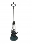 Antiga lamparina em metal, de composição vertical com base recortada e detalhes funcionais preservados, incluindo apagador e utensílios suspensos por correntes. Medidas: 51 cm.