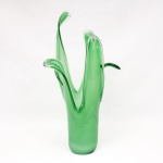 Vaso executado vidro soprado, corpo cilíndrico com transição orgânica para hastes ascendentes formando prolongamento verticais simulando folhagens. Tonalidade verde com variação de tons e zonas translúcidas. Bordas modeladas a quente com espessamento nas extremidades. Medidas: Alt.: 50 x Diam.: 15,5 cm. Base apresenta ínfimo trincado na borda.